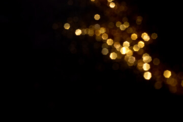 Golden blurred bokeh lights on black background. Glitter sparkle stars for celebrate. Overlay for your design - obrazy, fototapety, plakaty