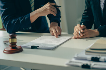 Male attorneys or judges consult teams with clients, business and legal services. The consultant presents the contract signed with the hammer placed in front and concept of justice and lawyer