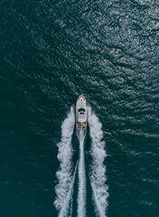 Aerial top down view of speed motor boat on open sea at summer day