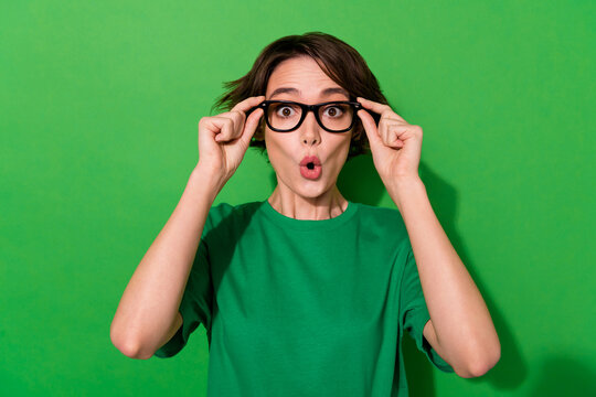 Portrait of impressed person hands touch glasses pouted lips isolated on green color background