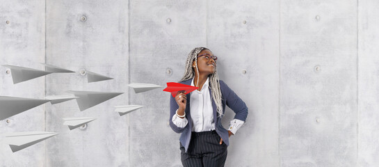 Young beautiful african woman holding hand model paper air plane. Design of travel concept with air...