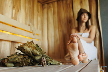 Selective focus of feet of attractive woman sitting in wooden sauna