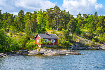 Small red cabin on scandinavian coastline