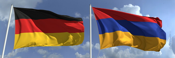 Flags of Germany and Armenia on flagpoles. 3d rendering