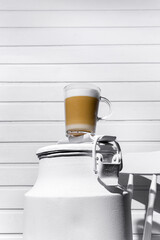 Glass of cappuccino with froth on a white can