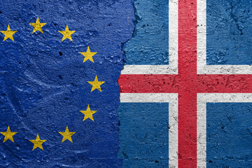 European Union and Iceland - Cracked concrete wall painted with a EU flag on the left and a Icelandic flag on the right stock photo