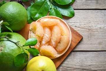 pomelo fruit on wooden plate  background, fresh green pomelo peeled and leaf frome pomelo tree , pummelo , grapefruit in summer tropical fruit  in thailand - 513735923