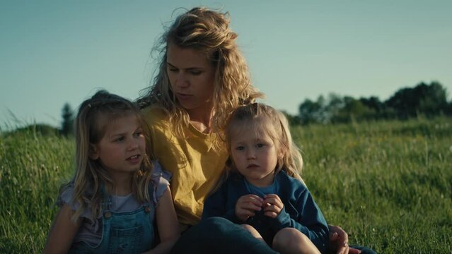 Mom with two little daughters bonding and spending time together at the meadow. Shot with RED helium camera in 4K.     