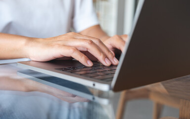 Closeup image of hands typing on laptop computer keyboard