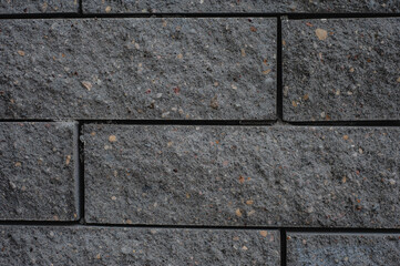 Black brick wall texture. Aged stone block masonry. Dark gloomy background