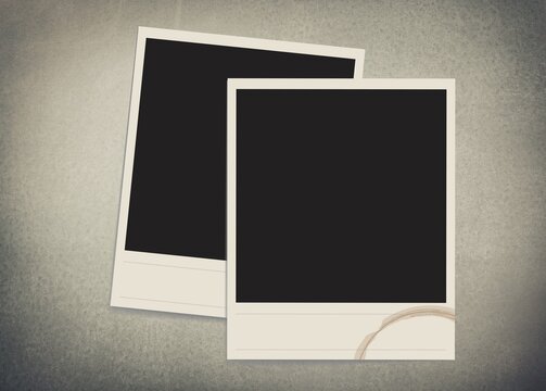 Two old vintage photo borders with tape on desk, blank frames.