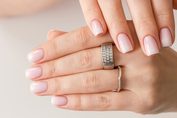 Female hands with beautiful nails with stylish trendy nude manicure.