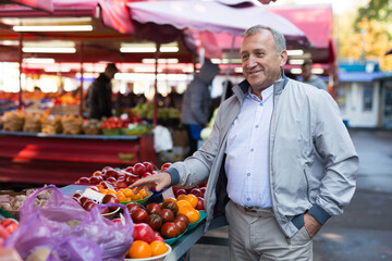 Man choosing vegetables in greengrocery