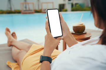 woman holding a white screen phone relaxing on the pool - 513744136