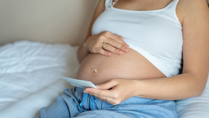 Fototapeta na wymiar Ultrasound photo pregnancy baby. Woman holding ultrasound pregnant picture. Concept maternity, pregnancy, childbirth.