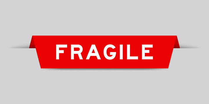 Red color inserted label with word fragile on gray background