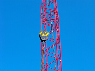 Tower crane segment with hook suspension and 45 tons capacity sign isolated on blue sky