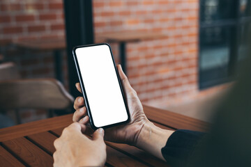 cell phone blank white screen mockup.hand holding texting using mobile on desk at office.background empty space for advertise.work people contact marketing business,technology