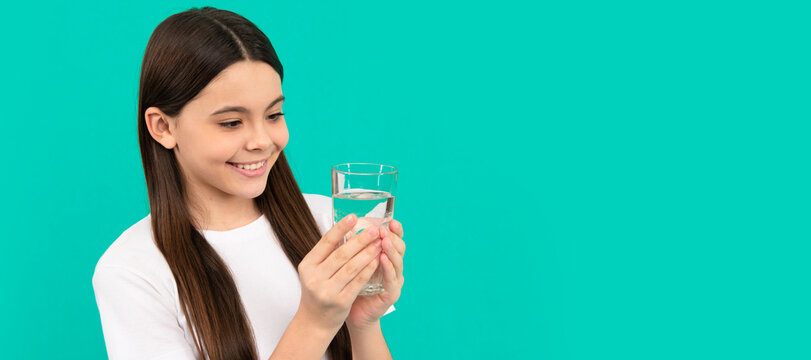 happy kid going to drink glass of water to stay hydrated and keep daily water balance. Banner of child girl with glass of water, studio portrait with copy space.