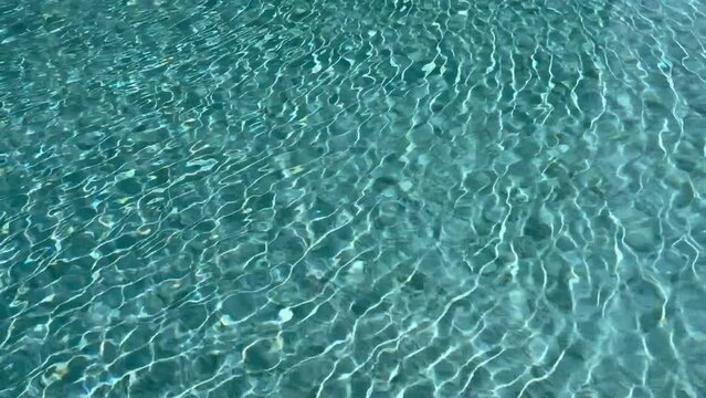 Water ripples in a swimming pool reflecting sunlight.Turquoise or blue water waves for background and abstraction.