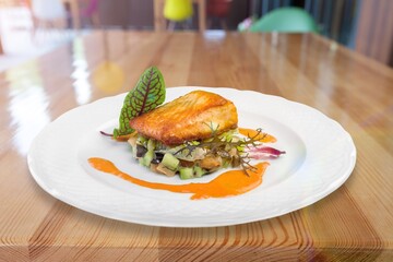 Fried fish with vegetable and salad on ceramic plate