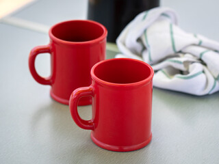 Blank red ceramic mugs on light background. High quality photo