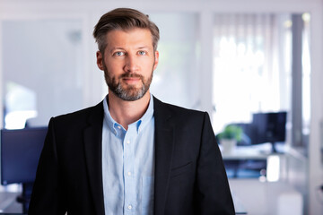 Handsome businessman portrait while standing at the office