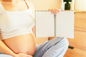 Pregnancy list woman writing. Beautiful pregnant woman writing check list. Happy pregnancy lady...