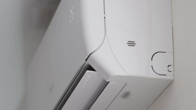 Modern air conditioner in the office with movable shutters. Cooling and heating the air to a comfortable temperature, close-up