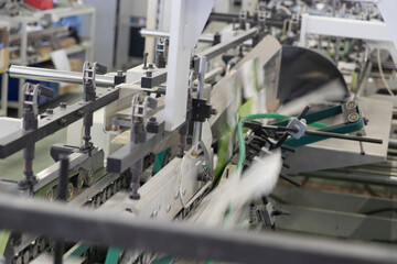 Close up detail of industrial machinery at work in a production line, conveyor belts are visible,...