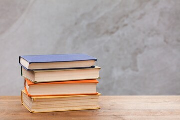 Stack of books on wooden desk