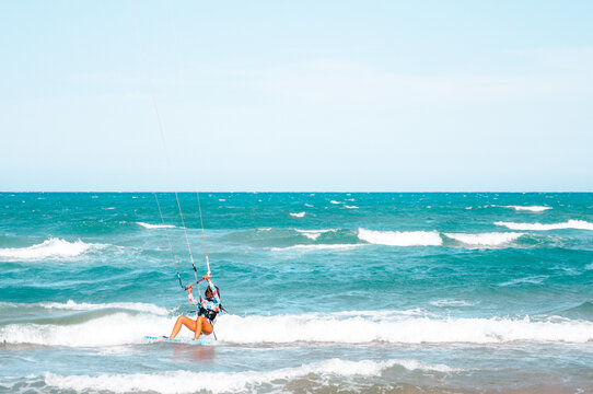 Joven surfera disfrutando haciendo kite surf en la playa. 
