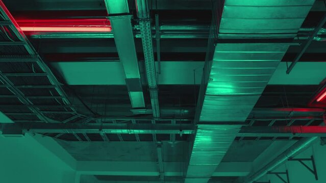 Electrical and air systems communications with cables and metal pipes inside modern building , parking or factory . Concept of electric construction equipment . Communication under ceiling .