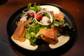 Salad smoke Salmon on plate on the table