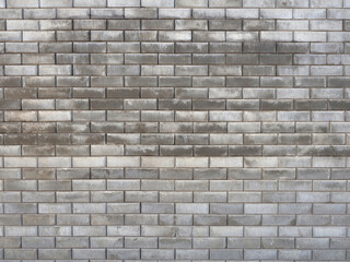 The outer wall of the building is made of gray bricks. Building without finishing. Full screen photo. Not a seamless texture.
