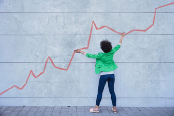 Young woman pointing at chart painted on wall