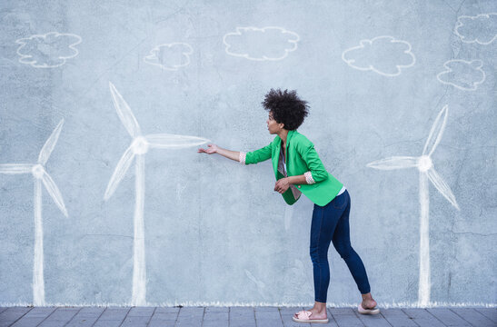 Woman explaining wind turbines painted on wall