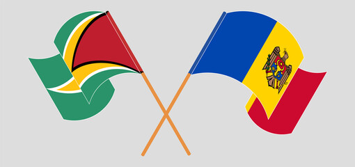 Crossed and waving flags of Guyana and Moldova