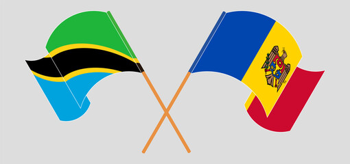 Crossed and waving flags of Tanzania and Moldova