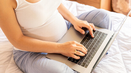 Pregnant computer. Pregnant woman holding digital laptop. Mobile pregnancy online maternity application. Concept of pregnancy, maternity, expectation for baby birth.