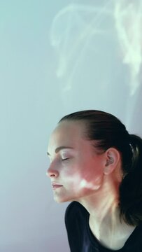 Spiritual energy. Peaceful meditation. Relaxed woman enjoying nirvana harmony in sunlight pink blue plash soothing motion isolated on neutral vertical. Mental health. Healing vitality. Calm recreation