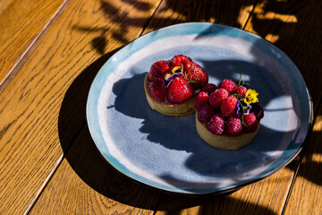 Cupcake with flower petals, strawberries, raspberries and cream