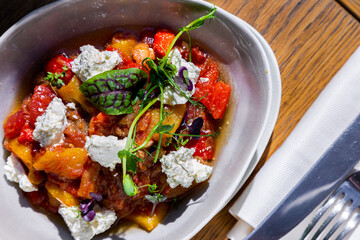 Salad with cheese, tomatoes, pea sprouts, sorrel, meat gravy