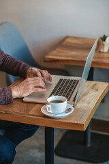 Fototapeta na wymiar Male hands over laptop keyboard indoors