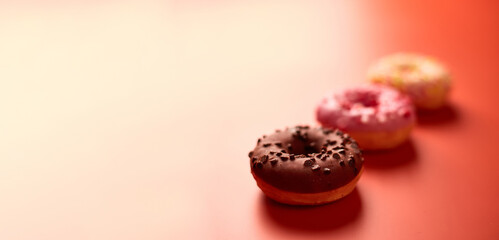 colorful donuts on orange background. Copy space