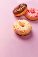 colorful donuts on purple background. Copy space