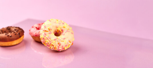 colorful donuts on purple background. Copy space