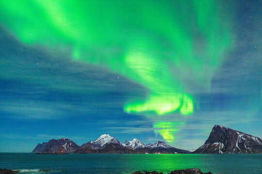 Bright green lights of Aurora Borealis (Northern Lights) reflecting in the sea, Myrland, Leknes, Vestvagoy, Lofoten Islands, Norway, Scandinavia