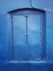 Closed blue windows on a blue wall