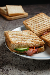 Close up of grilled ham sandwich, with vegetables and cheese. Selective focus.